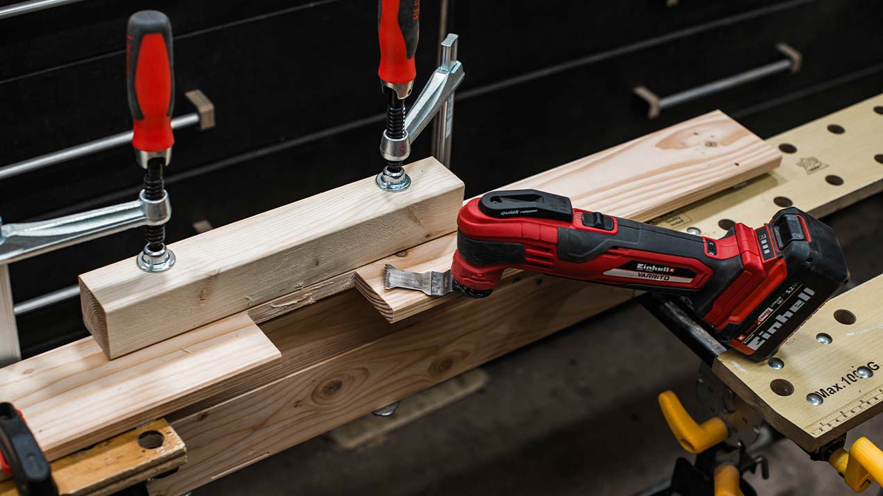 The multitool is lying on a wooden board and is ready for use