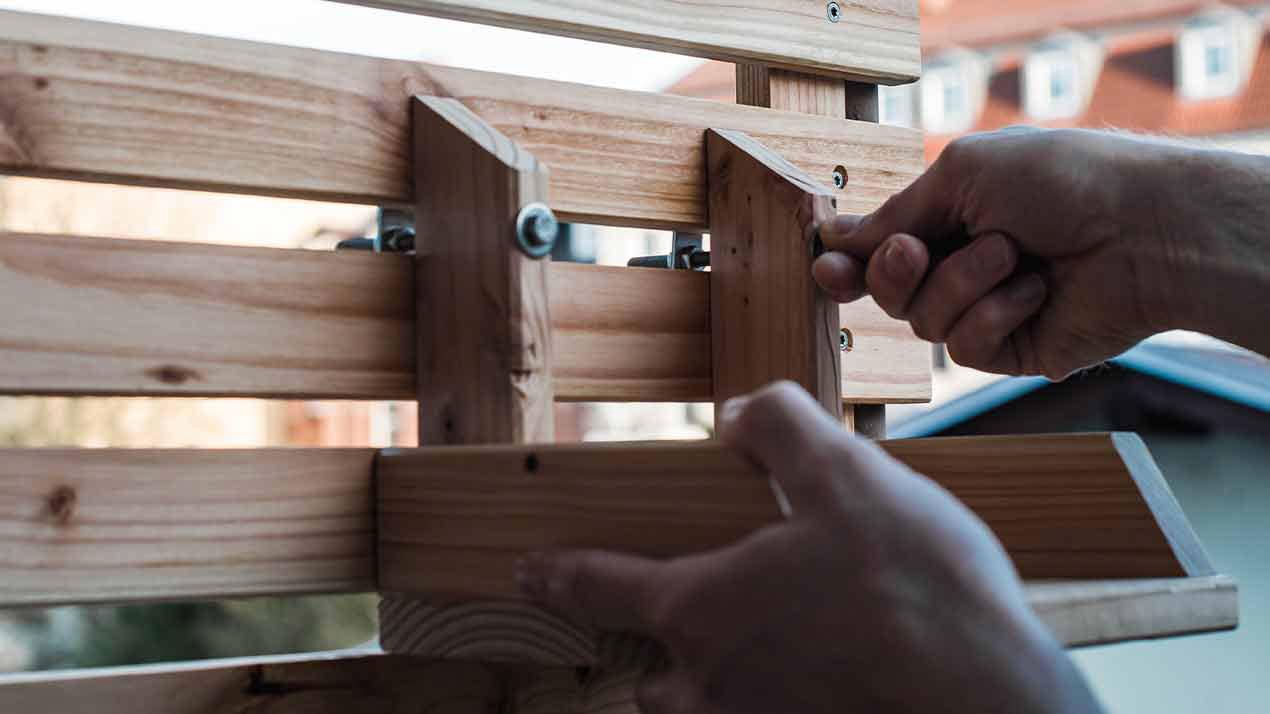 Hanging shelf is being attached to the wooden cladding