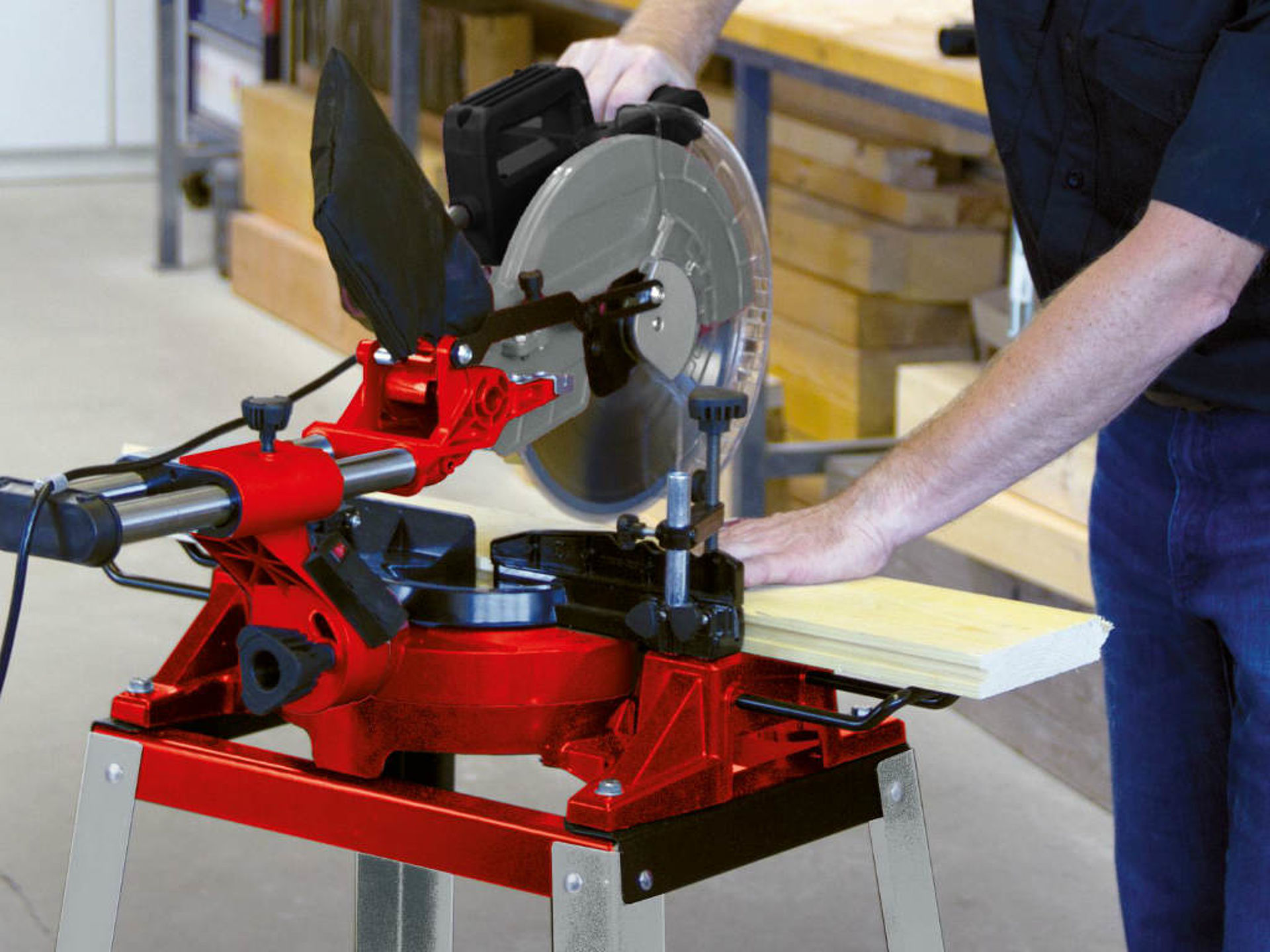 An Einhell circular table saw is used to cut a wooden board apart.