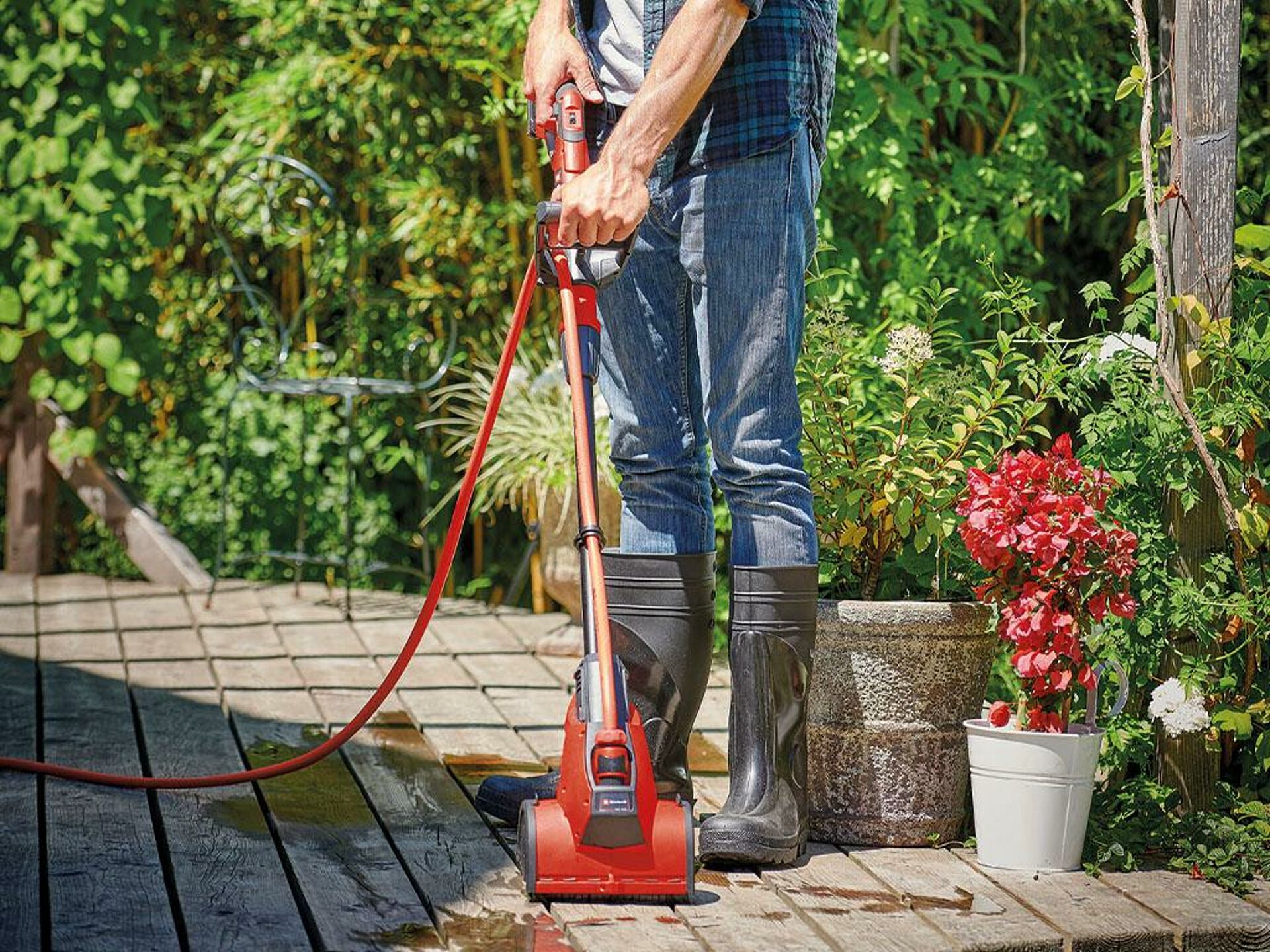 A paved floor is cleaned with an Einhell surface brush