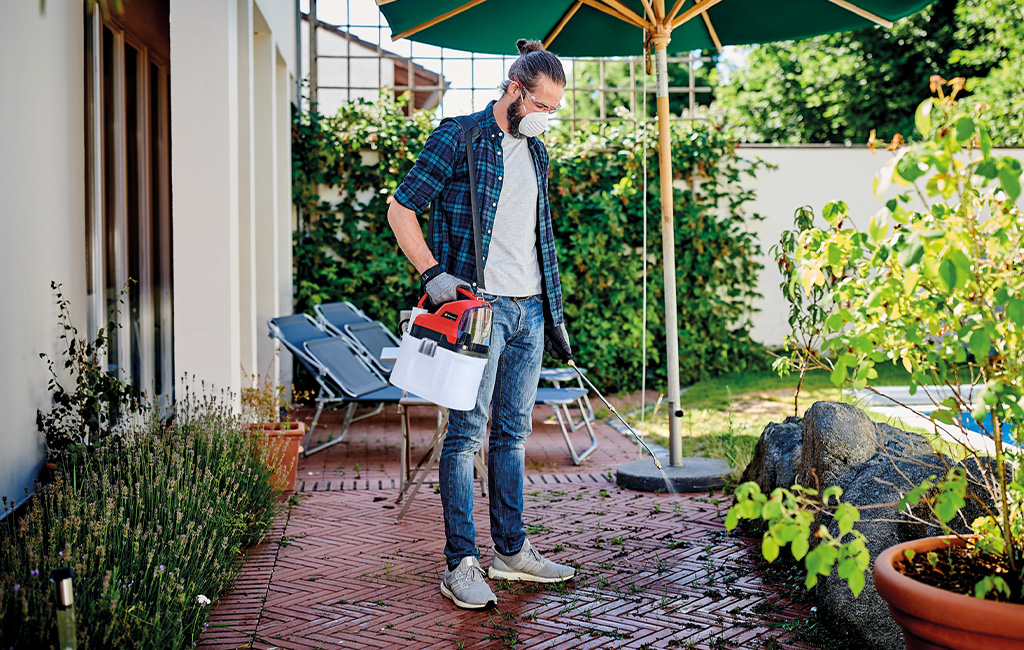 A man using the cordless pressure sprayer.