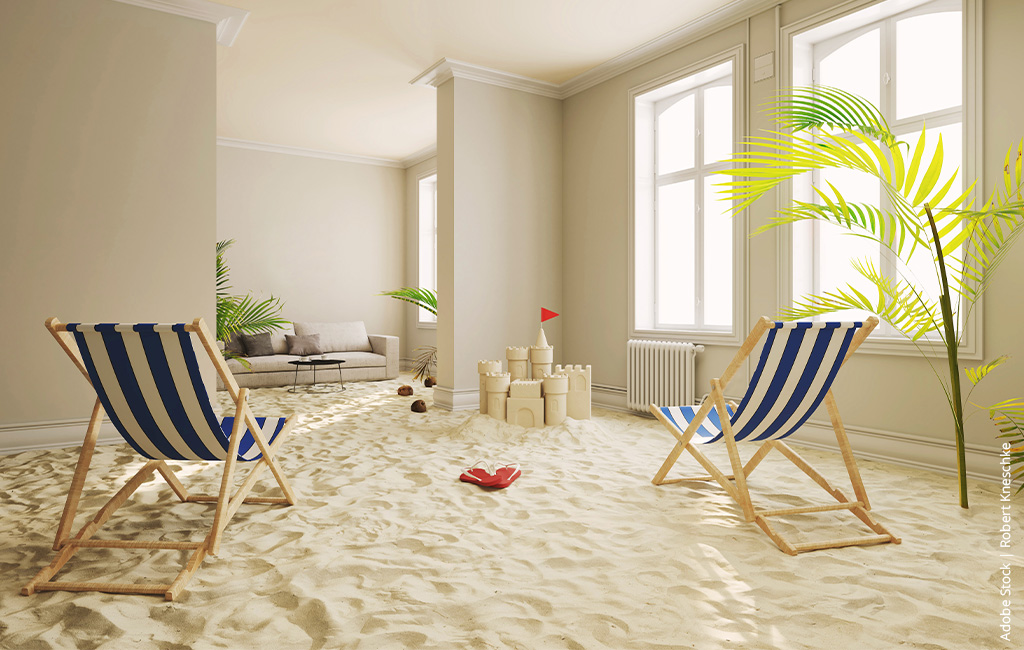 Beach loungers in a living room full of sand