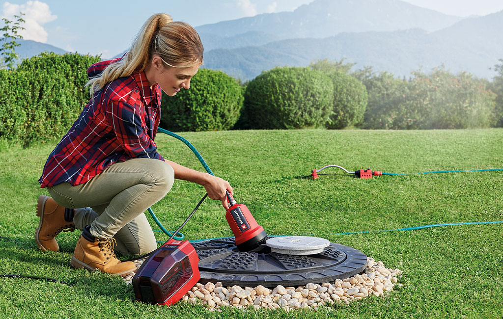 A woman is pumping water from a cistern with the Einhell cordless clear water pump 