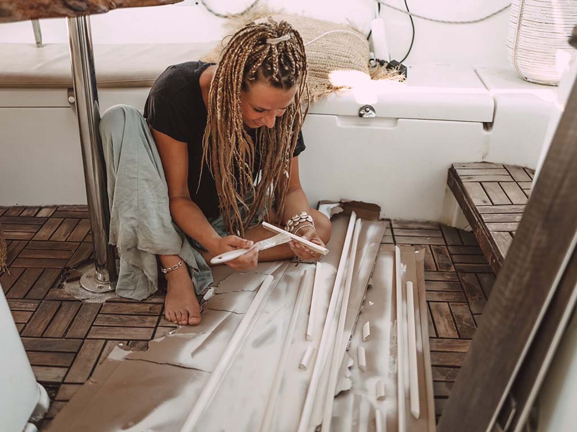  woman paints wooden pieces white