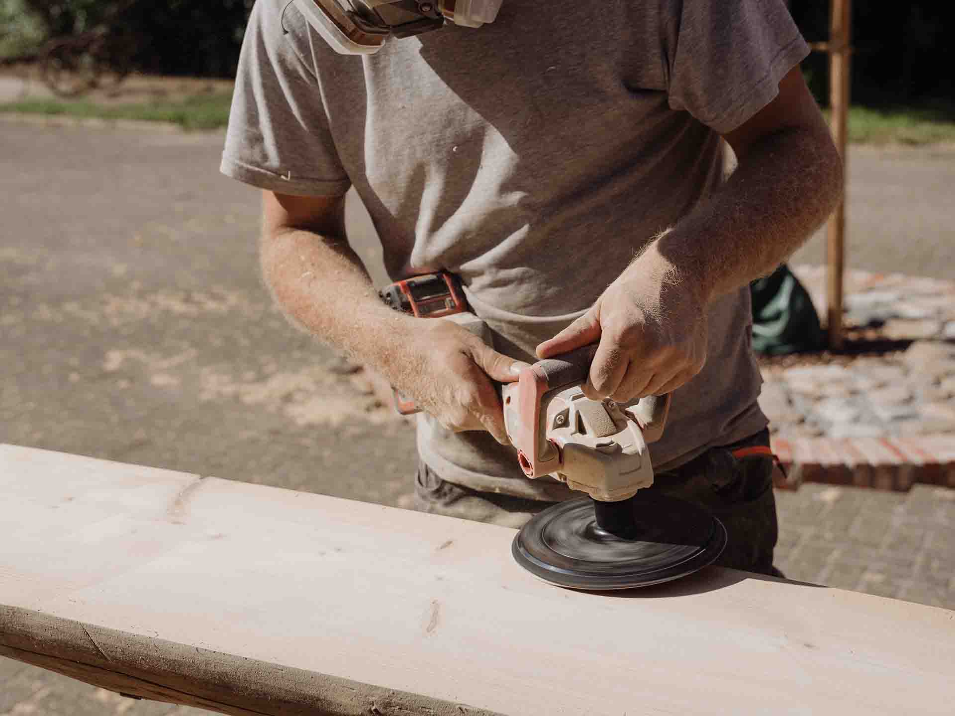 a man sands a log