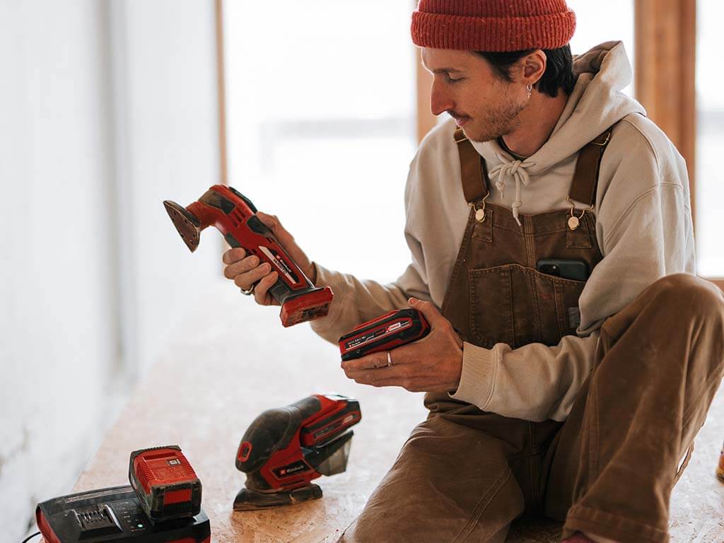 a man puts a battery into the grinder