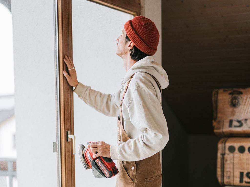 door wooden frame is sanded with a sander