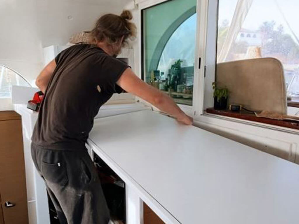 man lifts table into kitchen