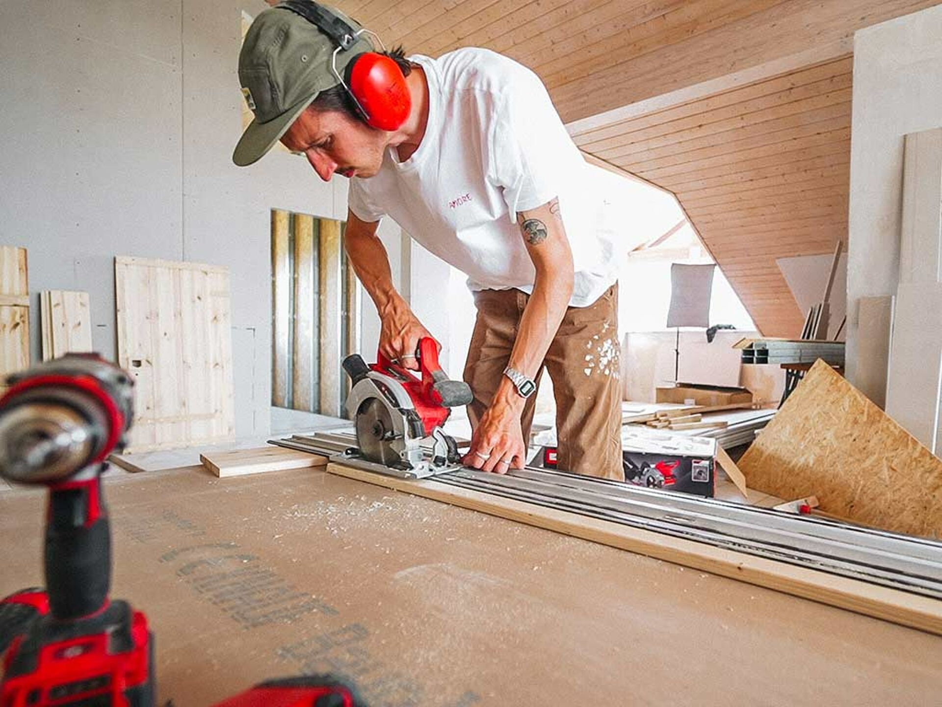 a man cuts a piece of wood along an iron strip