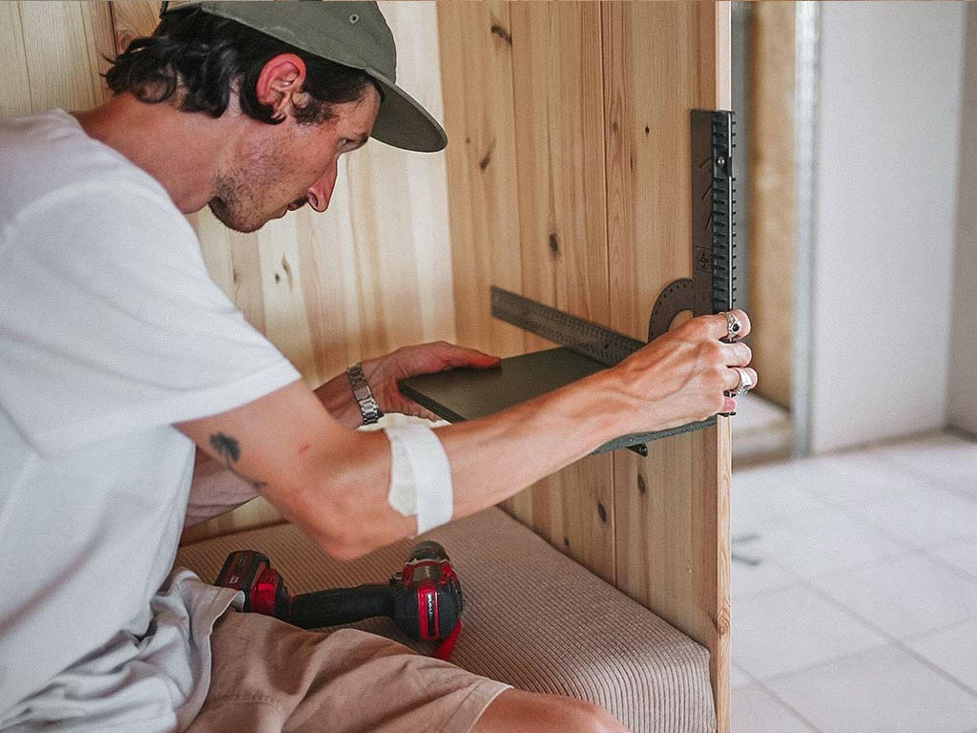 man measures an angle for a wooden board