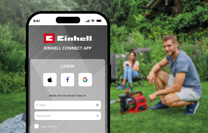 Ein Smartphone zeigt den Login-Bildschirm der Einhell-Connect-App, im Hintergrund ein Paar im Garten mit einer Pumpe.