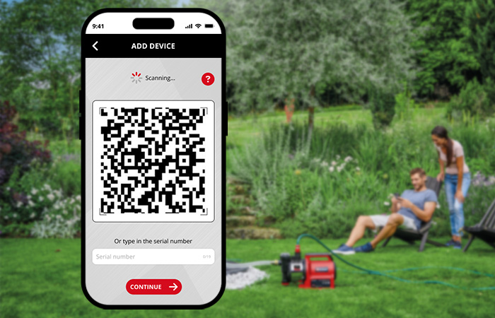 A smartphone displays the QR code scanner feature of the Einhell Connect app, with a pump in the garden background.