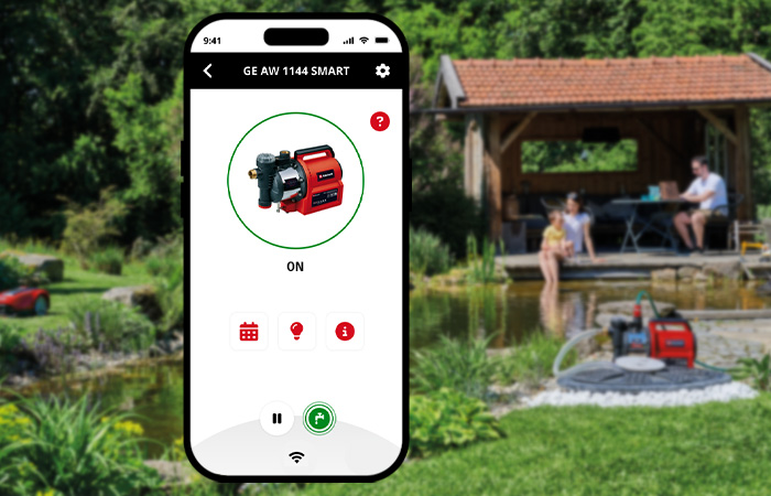 A smartphone displays the control interface of a pump in the Einhell Connect app, with a garden featuring a pond and pavilion in the background.